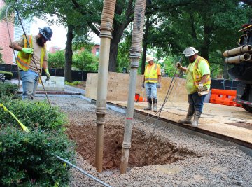 Construction workers working on a dug hole at Harrison Square on Tech campus